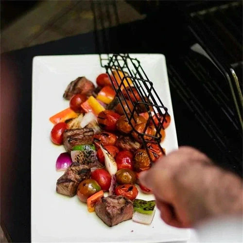 Person grilling vegetables and meat chunks on a plate. Hand visible holding skewer. Grilled to perfection with char marks.